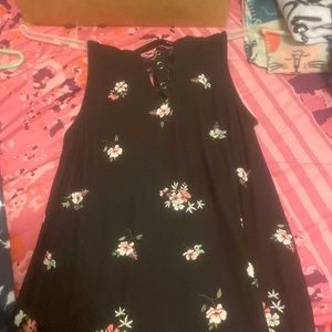 A black dress with flowers on it. It has 3 lines in the front for design.